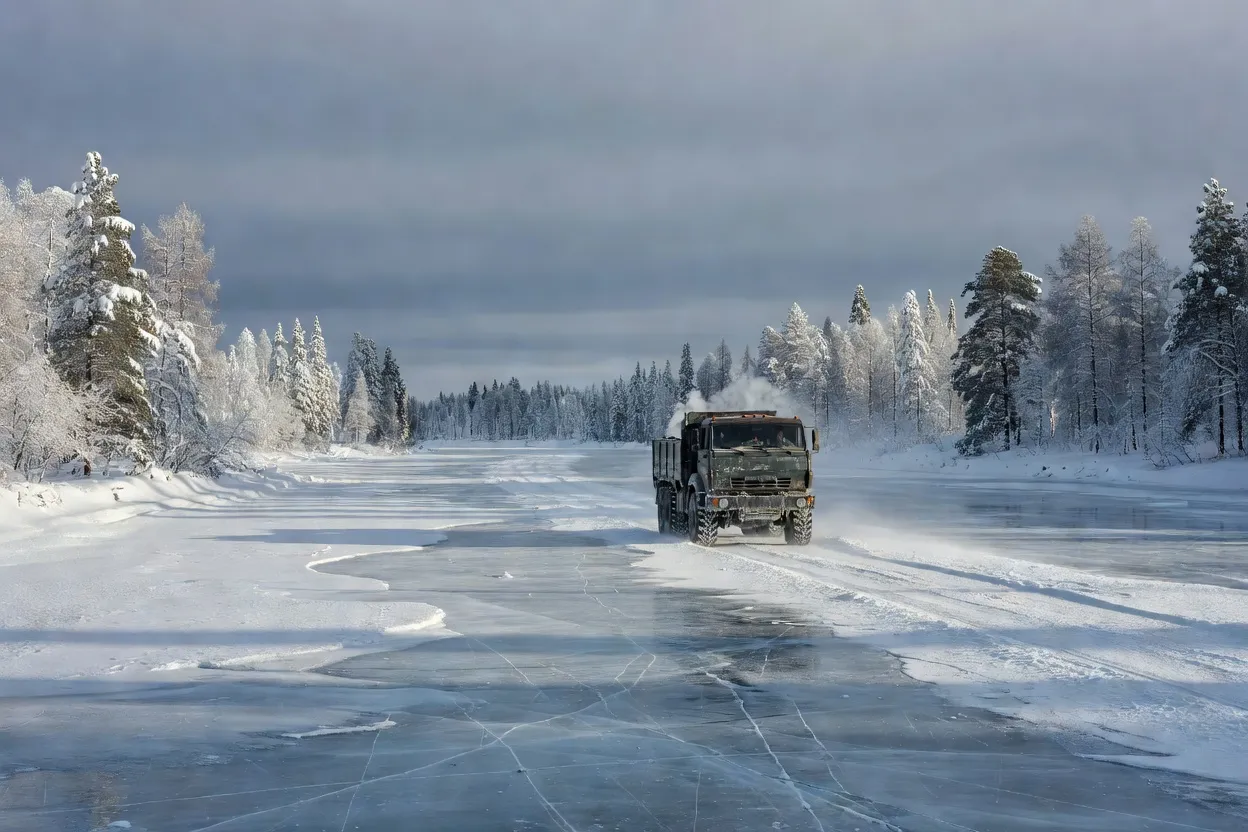 Camion roulant sur une route de glace zimnik tracée sur un fleuve gelé en Sibérie, sous ciel d'hiver